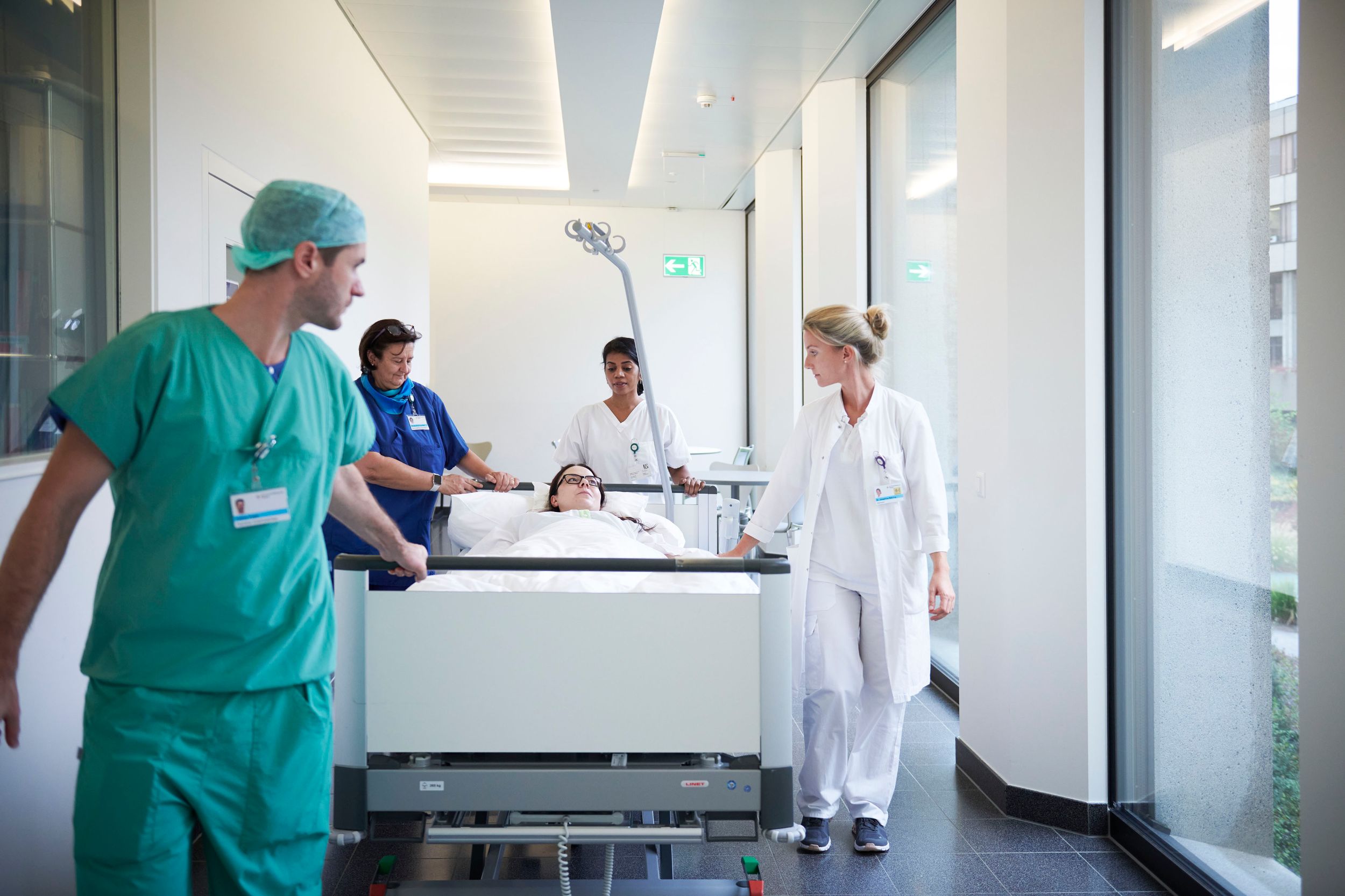 Médecins et infirmiers poussent une patiente dans un couloir