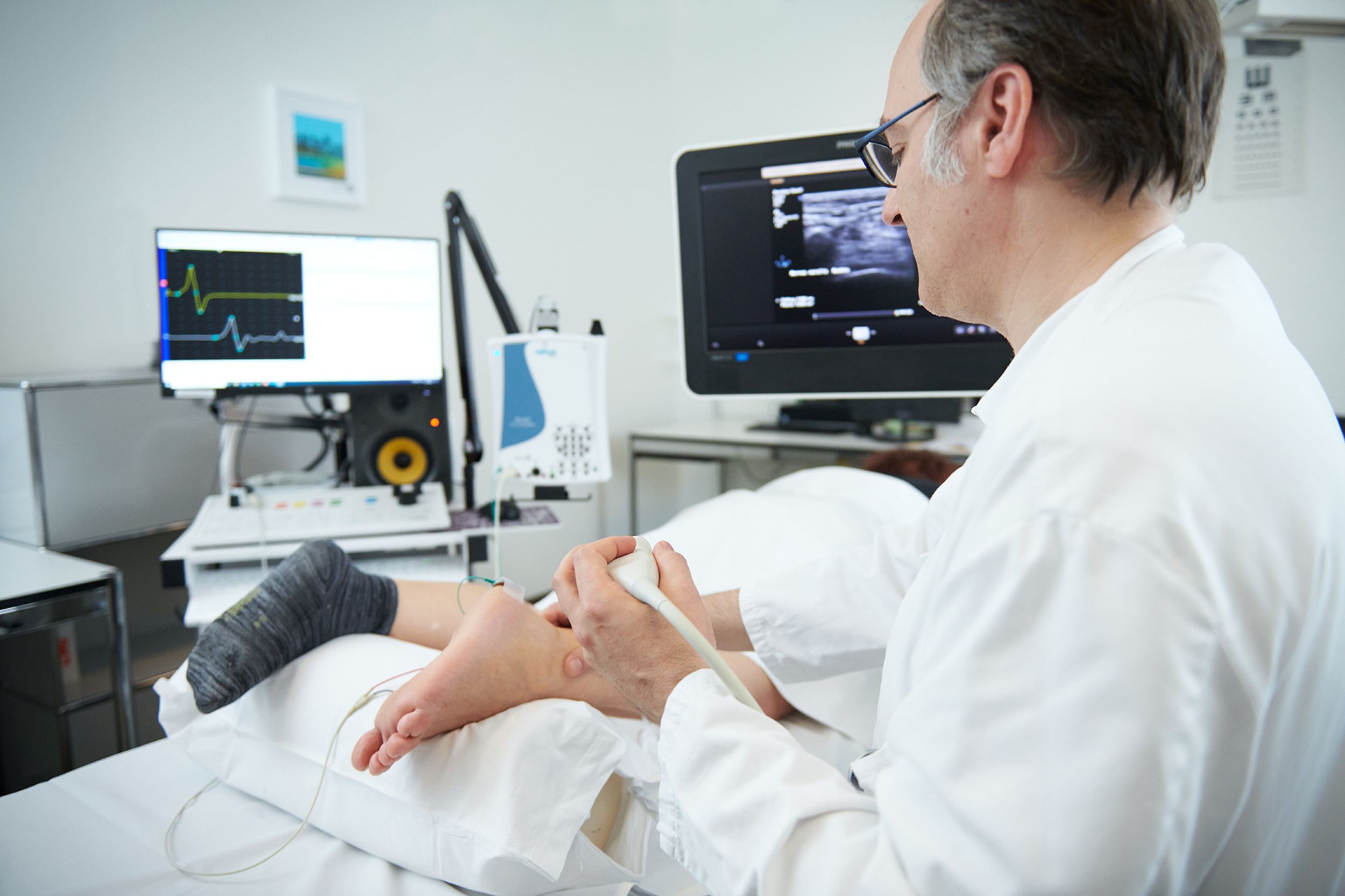 Arzt führt EMG-Untersuchung bei Patientin durch