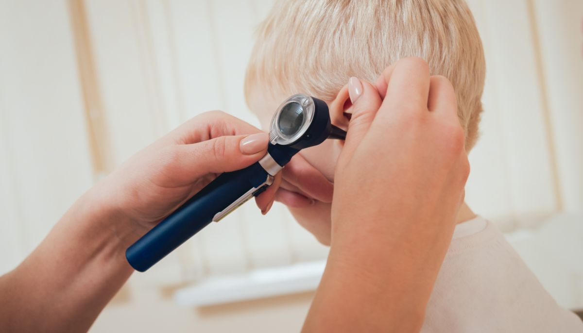 Doctor examines child's ear
