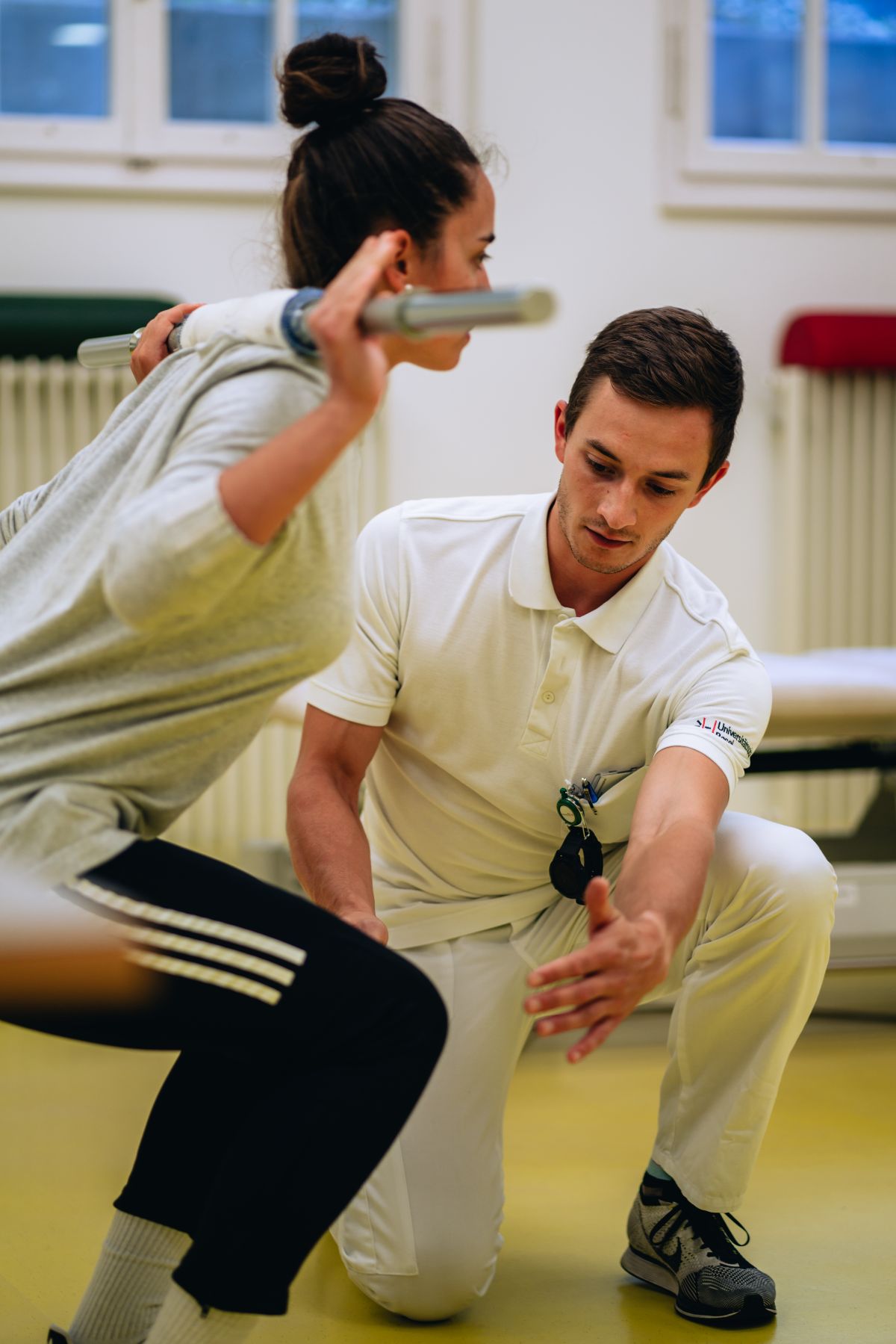 Physiotherapeut macht mit Patientin Rückenübungen