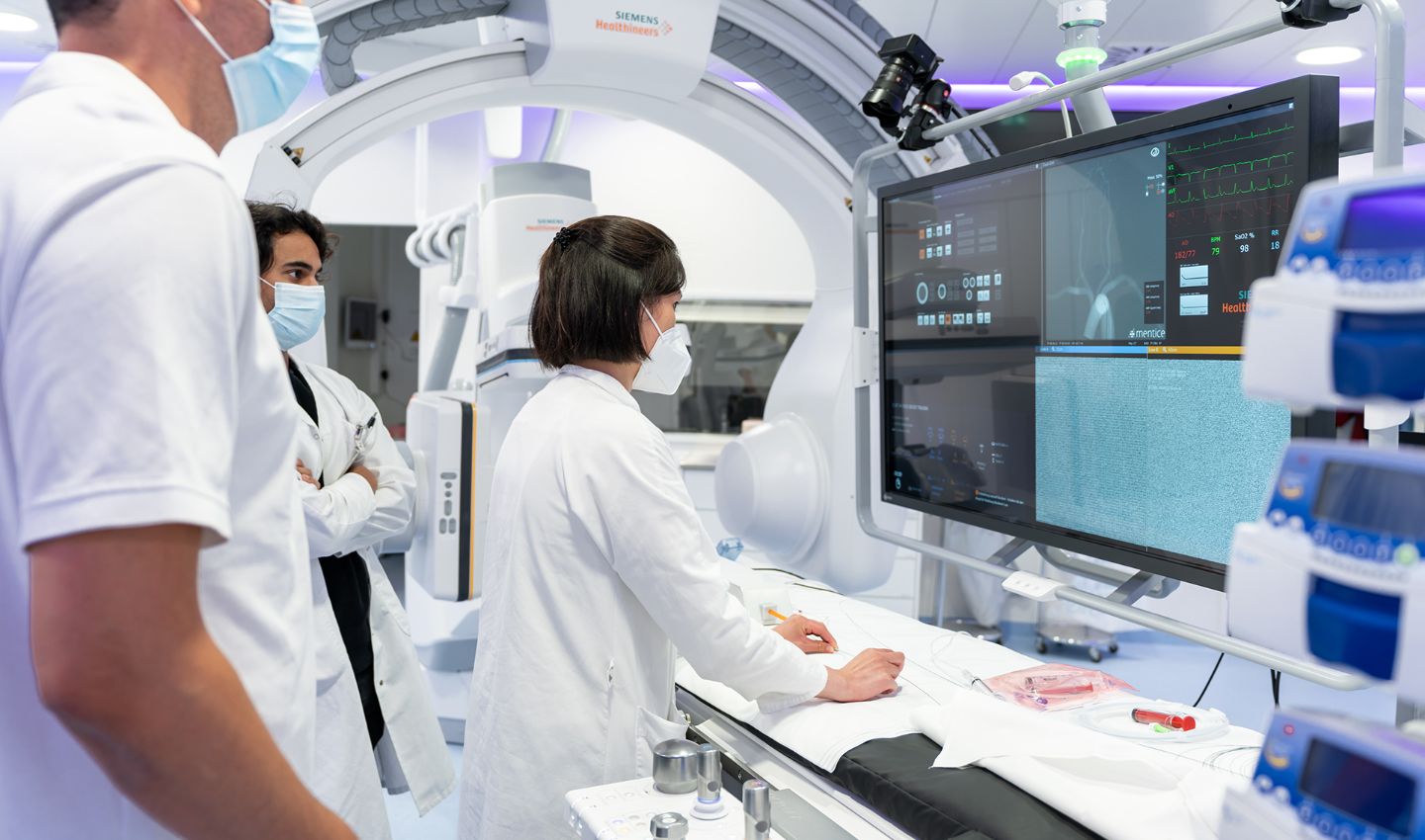 Radiologen und Radiologinnen vor Bildschirm in der Angio-Bildgebung