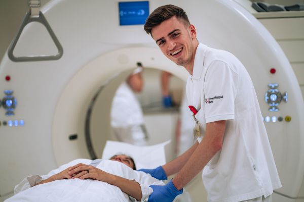 Radiologiefachmann mit Patienten vor einem CT