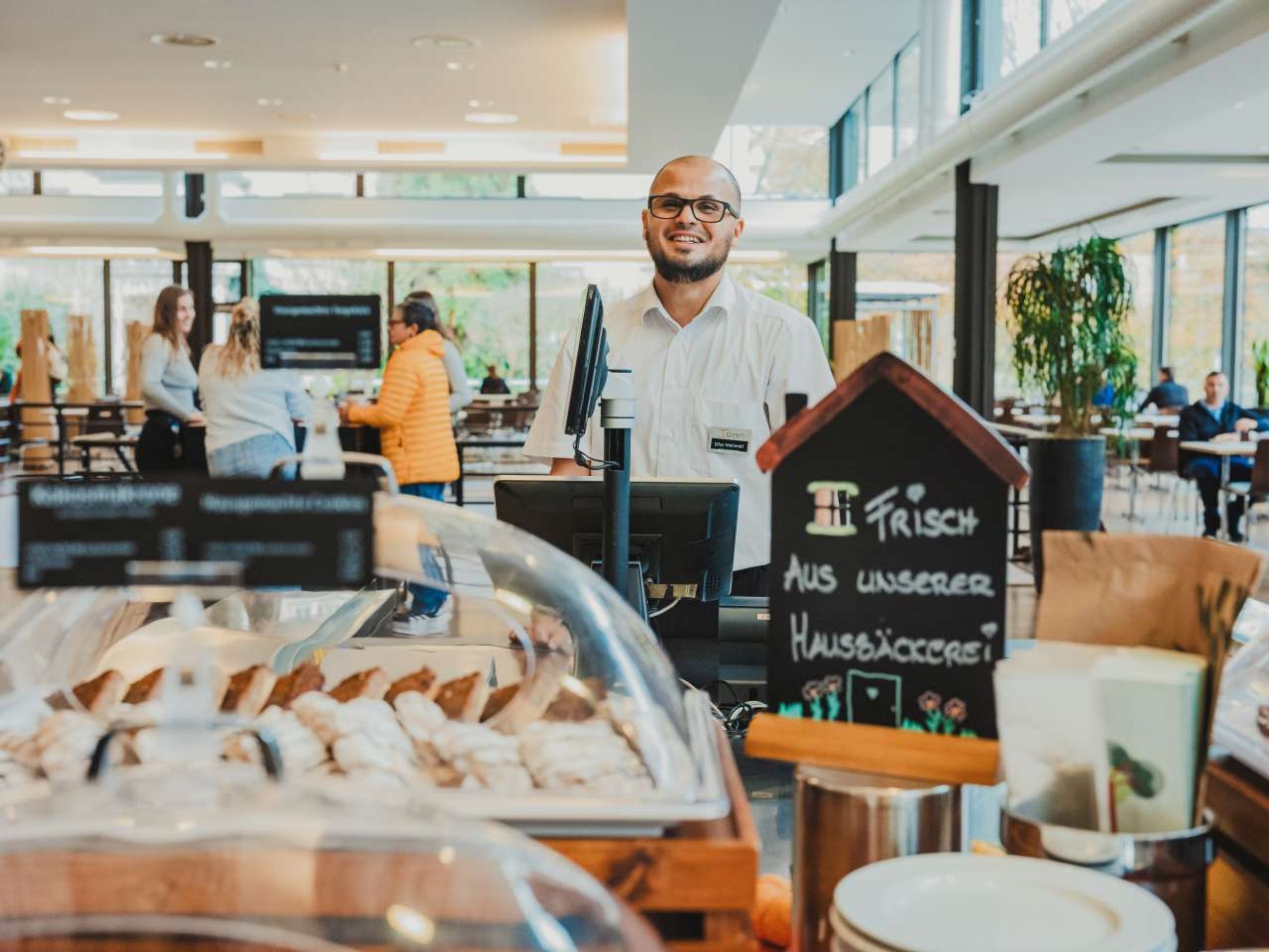 Gruppe von Frauen und Männern verschiedener Nationen in blauen und grünen OP-Kleidern