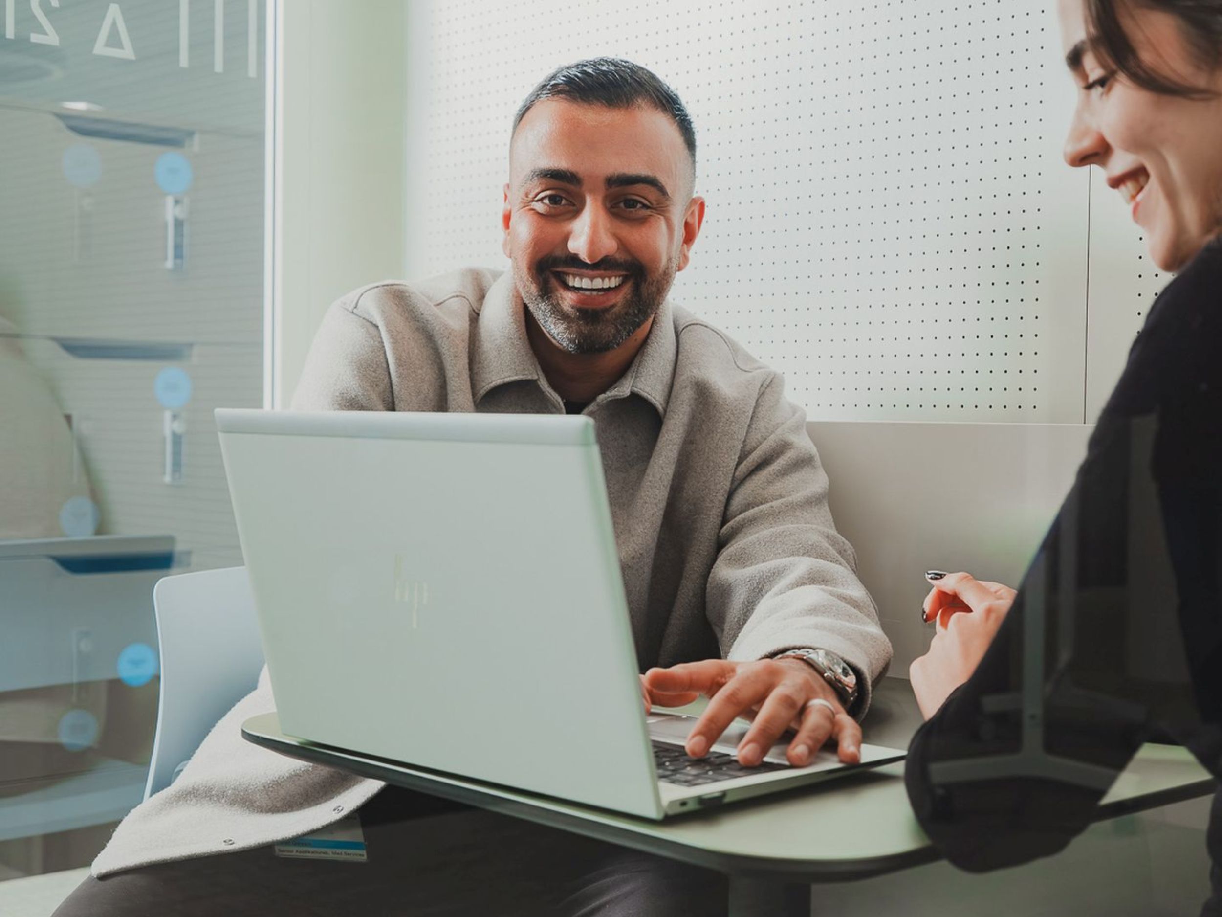 Mann mit Brille und Anzug zeigt mit einem Stift auf ein Flipchart