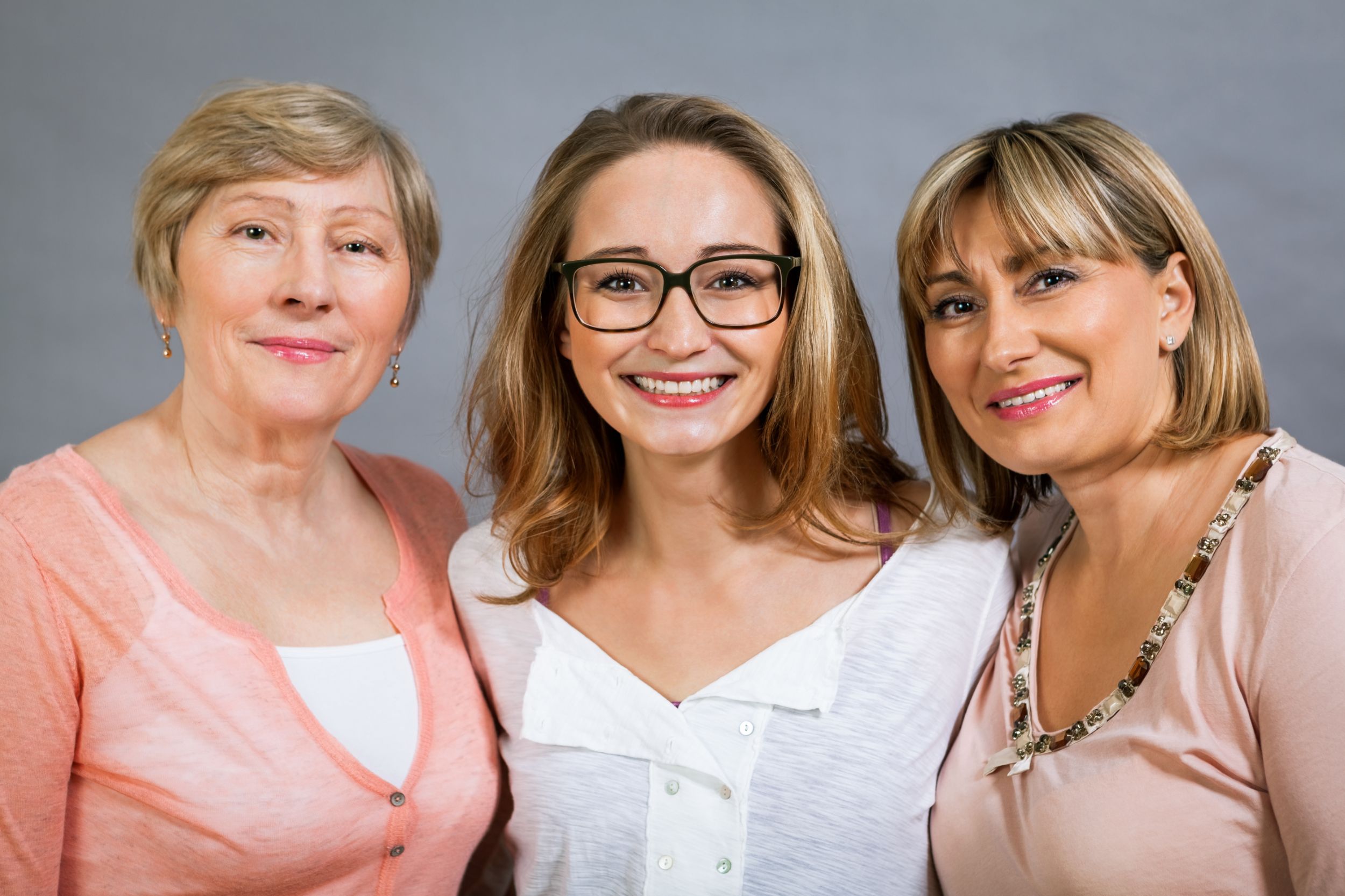 Drei Frauen stehen nebeneinander und lächeln
