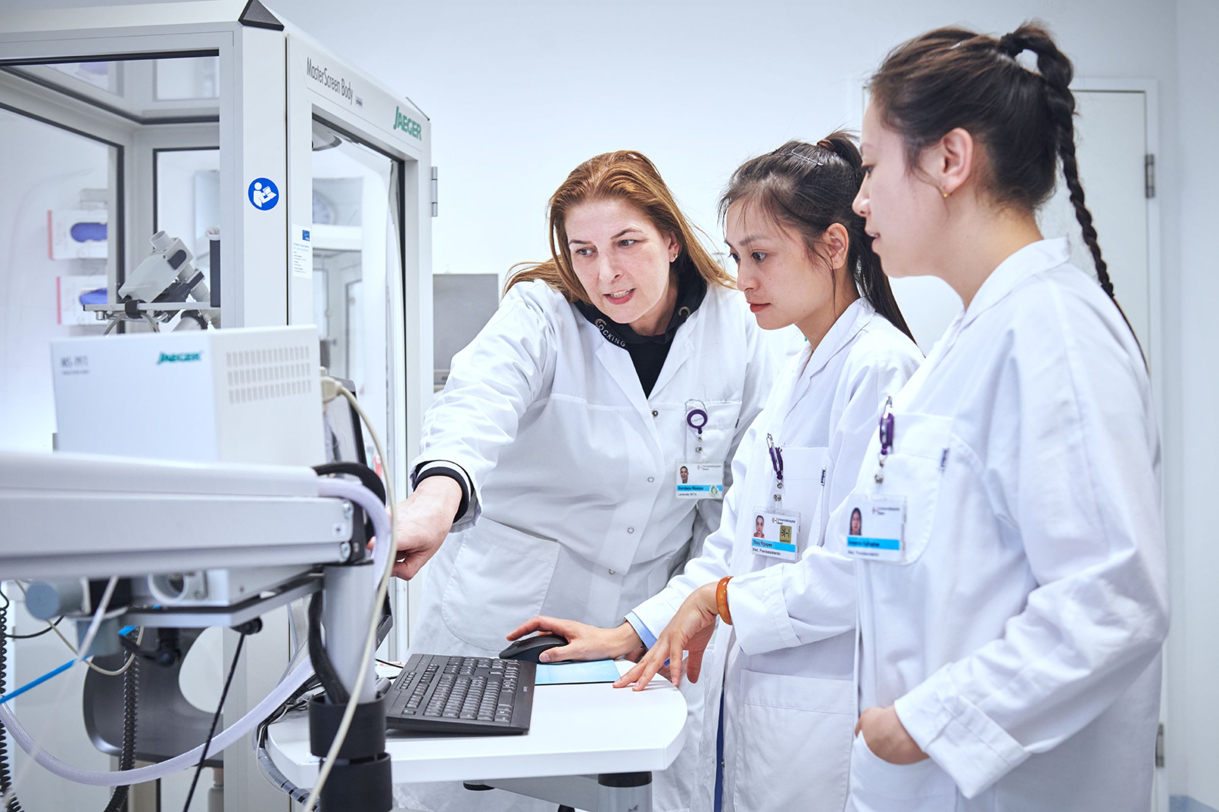 Three members of the pneumology department discuss something on a screen