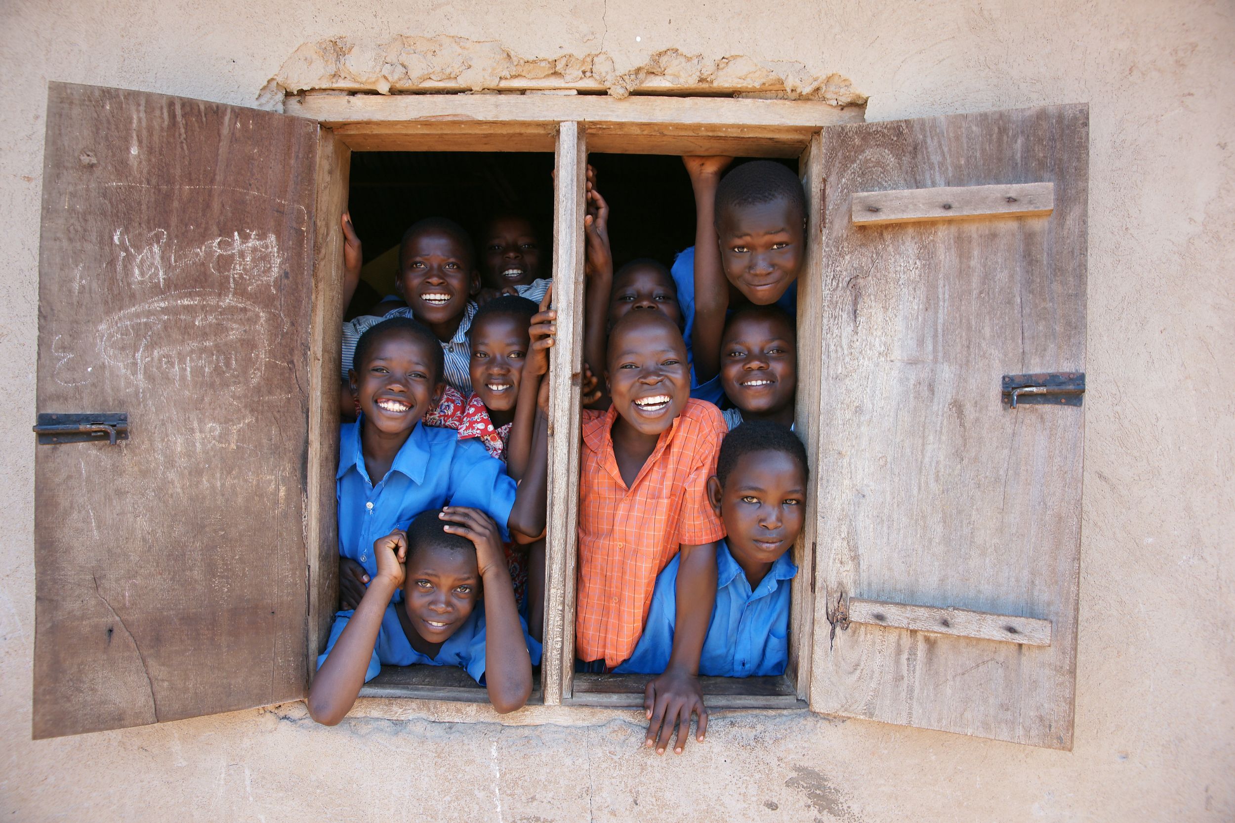Afrikanische Kinder schauen aus dem Fenster und lachen zusammen