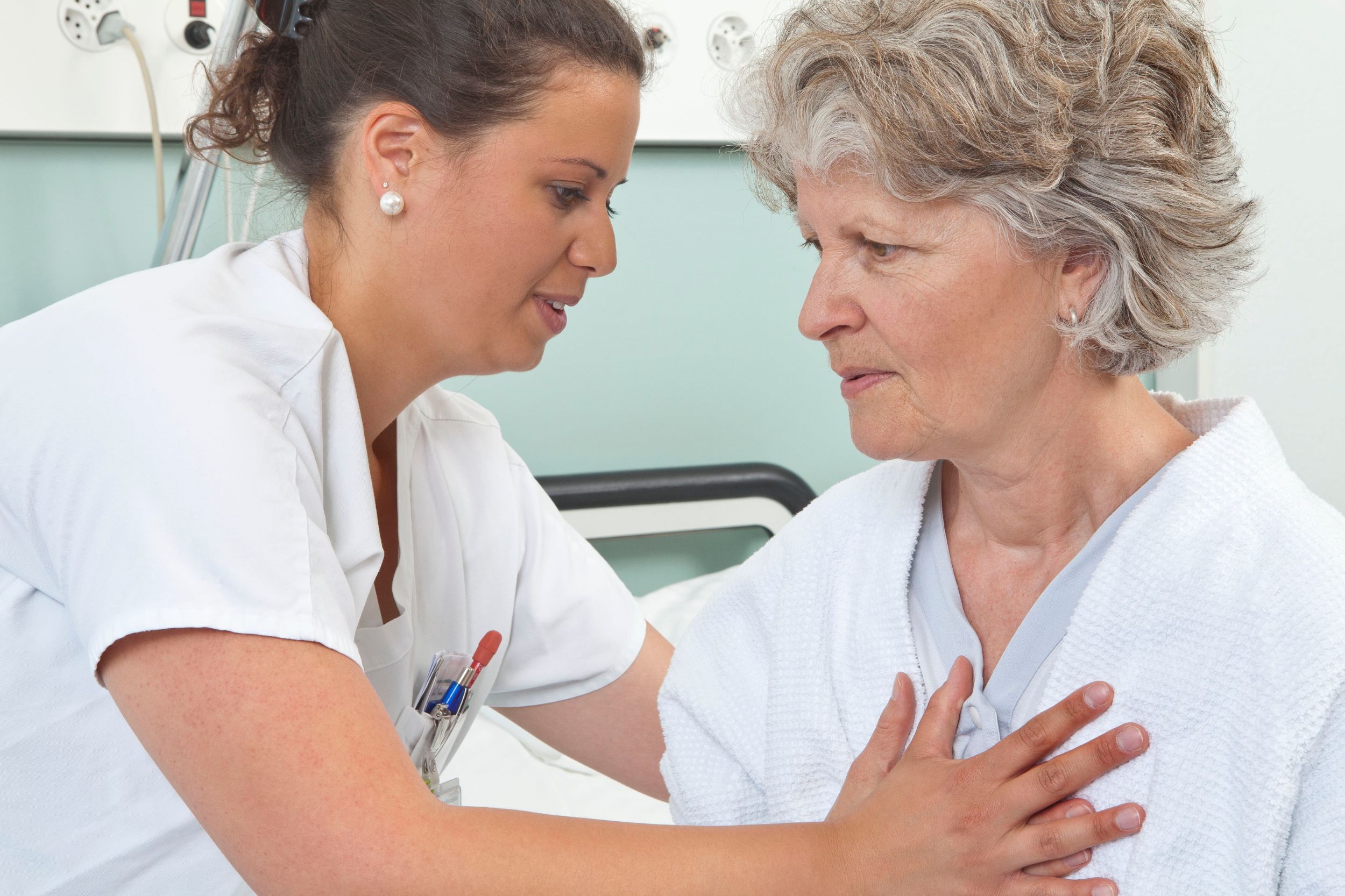 Ärztin hält Hand von Patientin.