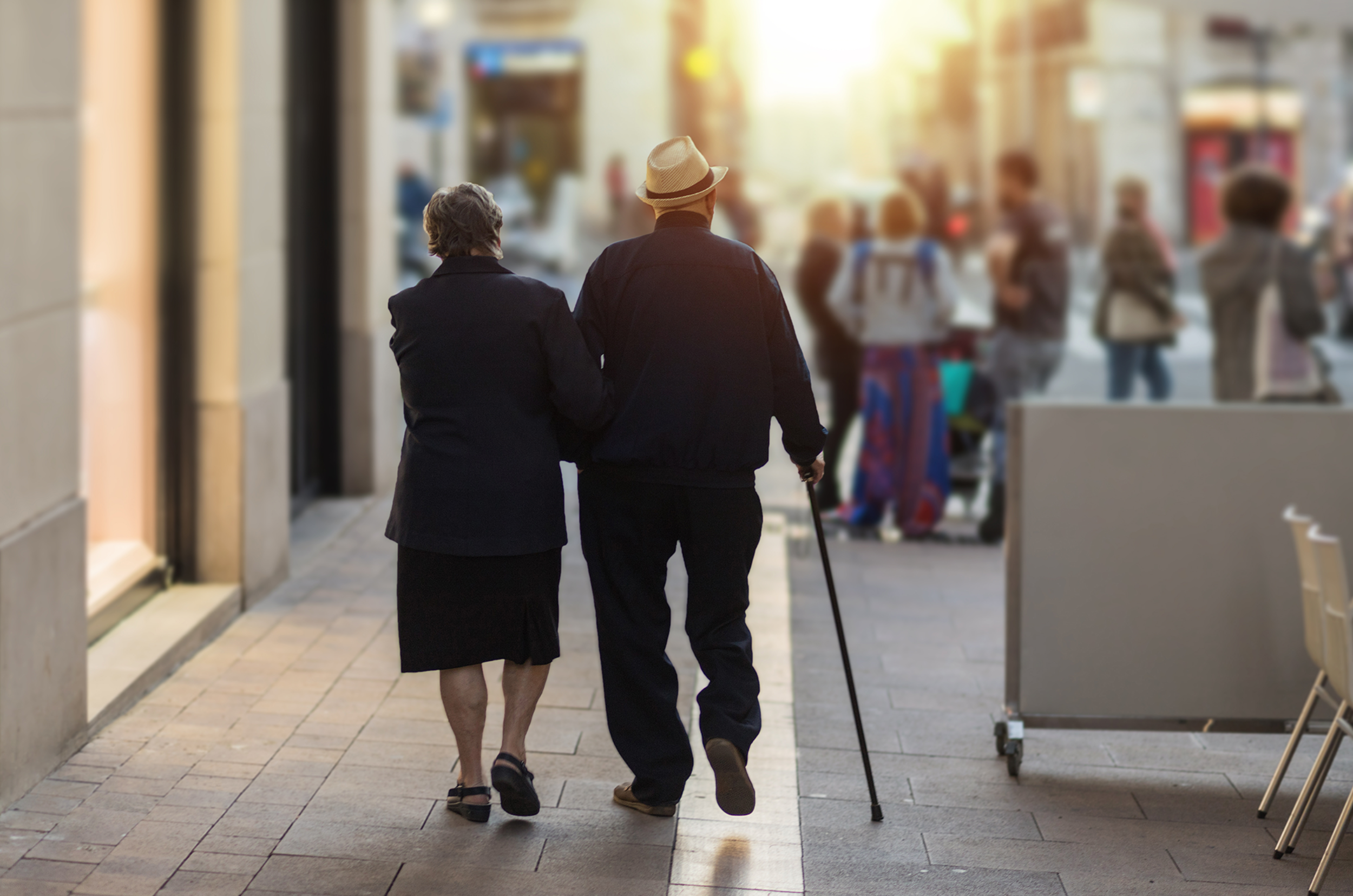 An elderly couple walking through the city.