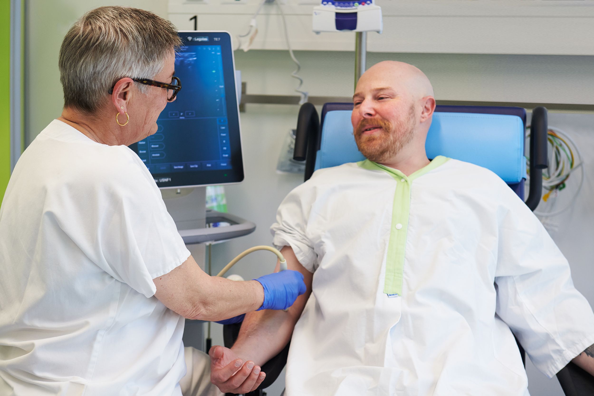Pflegefachperson führt eine Ultraschalluntersuchung an männlichem Patienten durch 