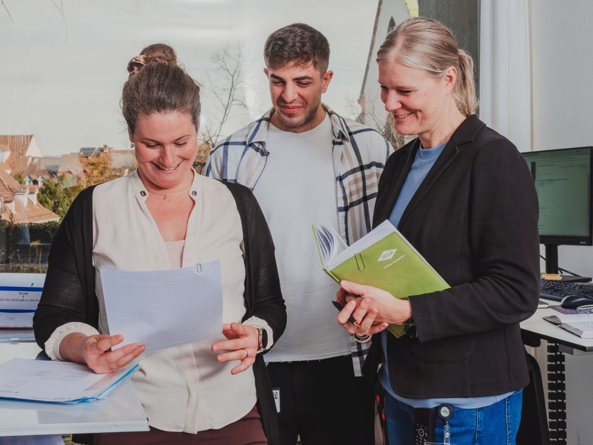 L'homme à lunettes et en costume montre un stylo sur un flipchart