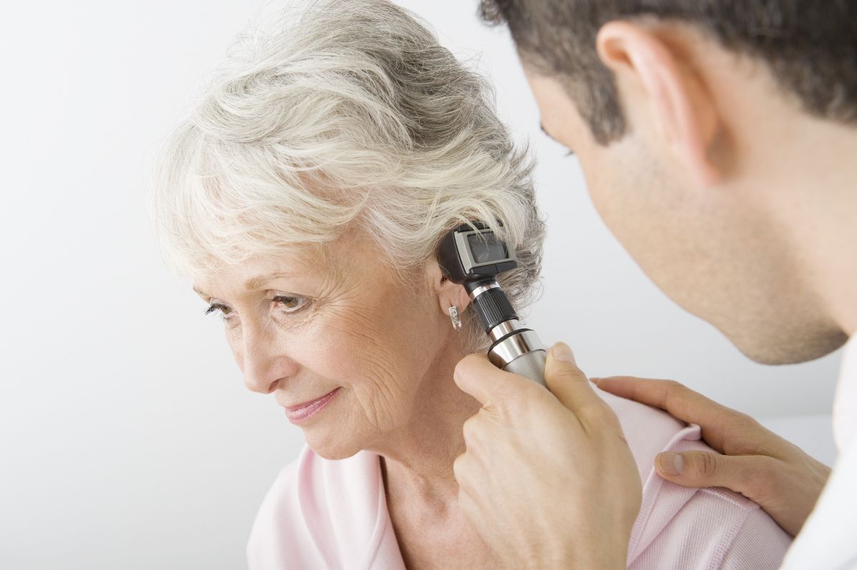 Arzt untersucht Ohr von Patientin