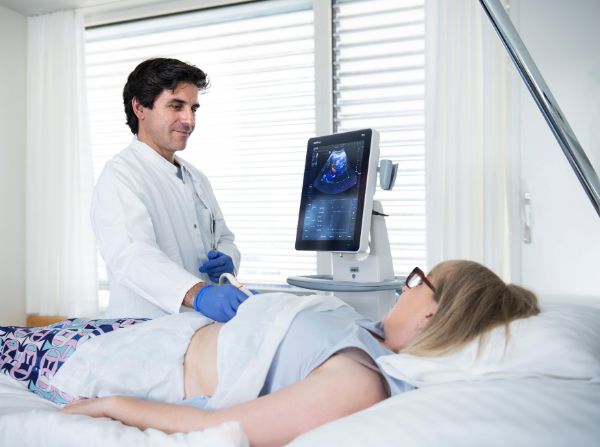 Arzt führt bei Patientin eine Sonografie durch