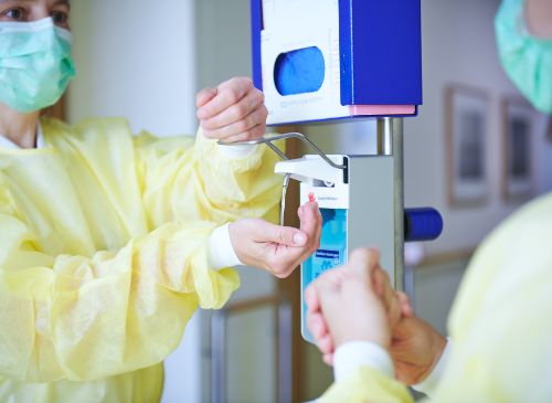 Two hospital hygiene staff while doing hand disinfection